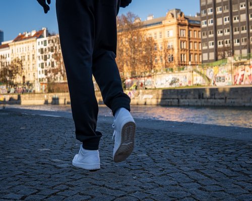 Person wearing comfortable sneakers while walking on a city sidewalk